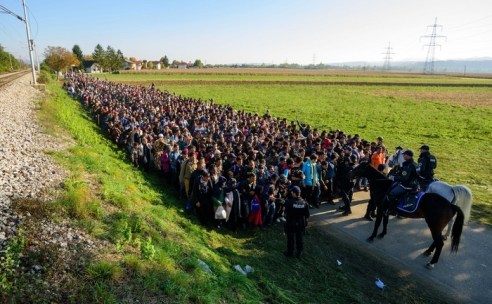 Police escort migrants and asylum seekers as they walk to a refugee centre after crossing the Croatian-Slovenian border near Rigonce on October 24, 2015. Bulgaria, Romania and Serbia threatened to close their borders if EU countries stopped accepting migrants, as European leaders prepared for a mini summit on the continent's worst refugee crisis since World War II. AFP PHOTO / JURE MAKOVEC (Photo credit should read Jure Makovec/AFP/Getty Images)