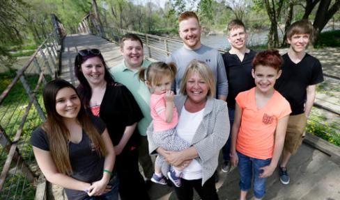 ADVANCE FOR SUNDAY, MAY 1, 2016 - In this Tuesday, April 26, 2016 photo, Denise Moore, center, in white, of Des Moines, Iowa, poses with her family, from left, daughter Alex Gibbs, Emily Bosch, son Kodi Baughman, granddaughter MacKenzie Moore, sons Kori Moore, Kelli Moore, daughter Andy Gibbs, and son Kasi Baughman during a visit to Water Works Park, in Des Moines, Iowa. Moore, a mother of seven, nearly lost her parental rights after her arrest in 2003 for conspiracy to deliver methamphetamine. (AP Photo/Charlie Neibergall)